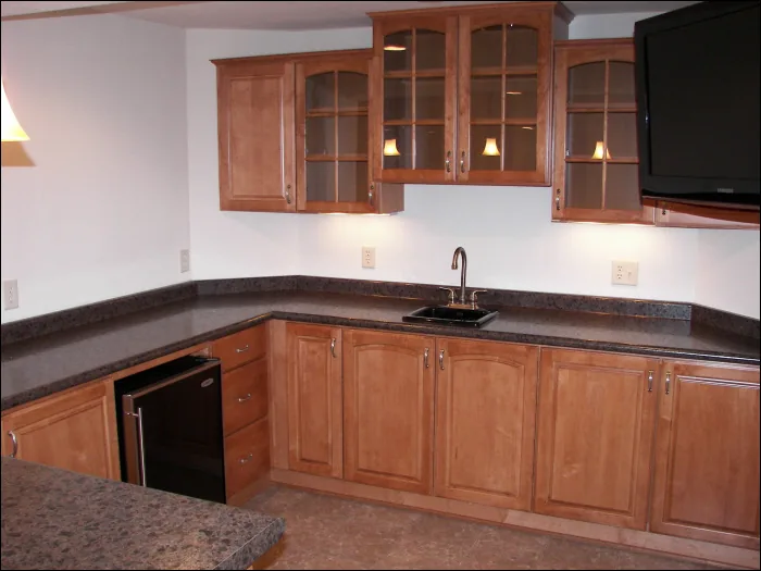 Franklin basement rec room with a bar, cabinetry and recessed lighting by Reality Construction