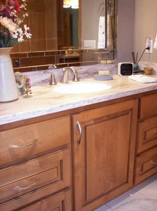 Saukville bathroom remodel with a stone countertop and wood vanity by Reality Construction